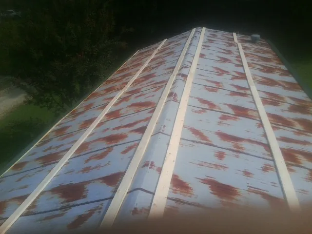 Rusted metal roof panels with new wood purlins before replacement — Storm Damage Roof Repair in Artois by Roofing Brothers