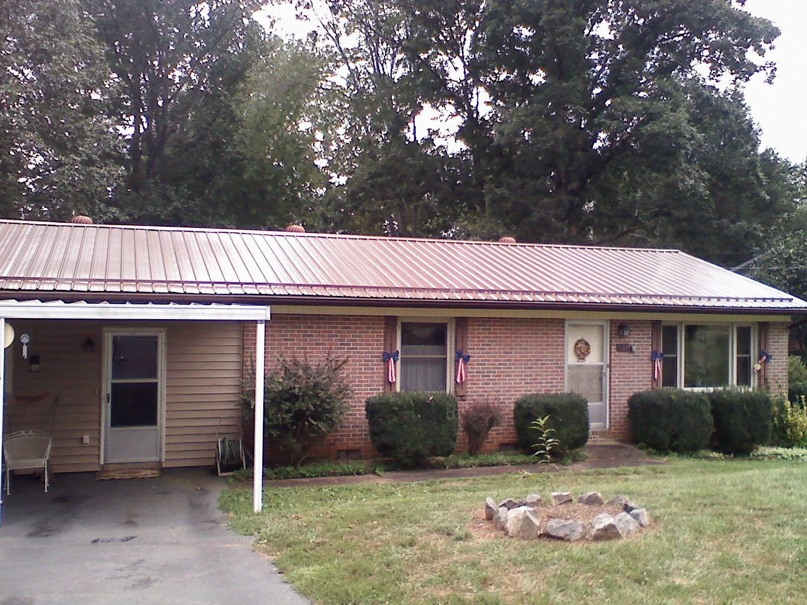 Bronze metal roof and carport on a brick ranch home — Roof Repair work by our crew in Artois